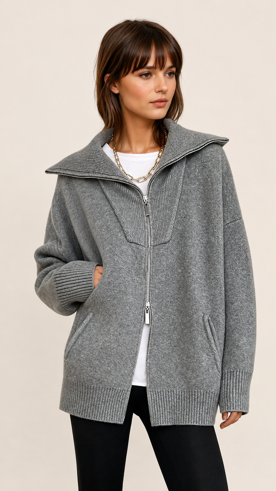 Grauer Oversize-Cardigan mit offenem Kragen auf warmem beigem Hintergrund