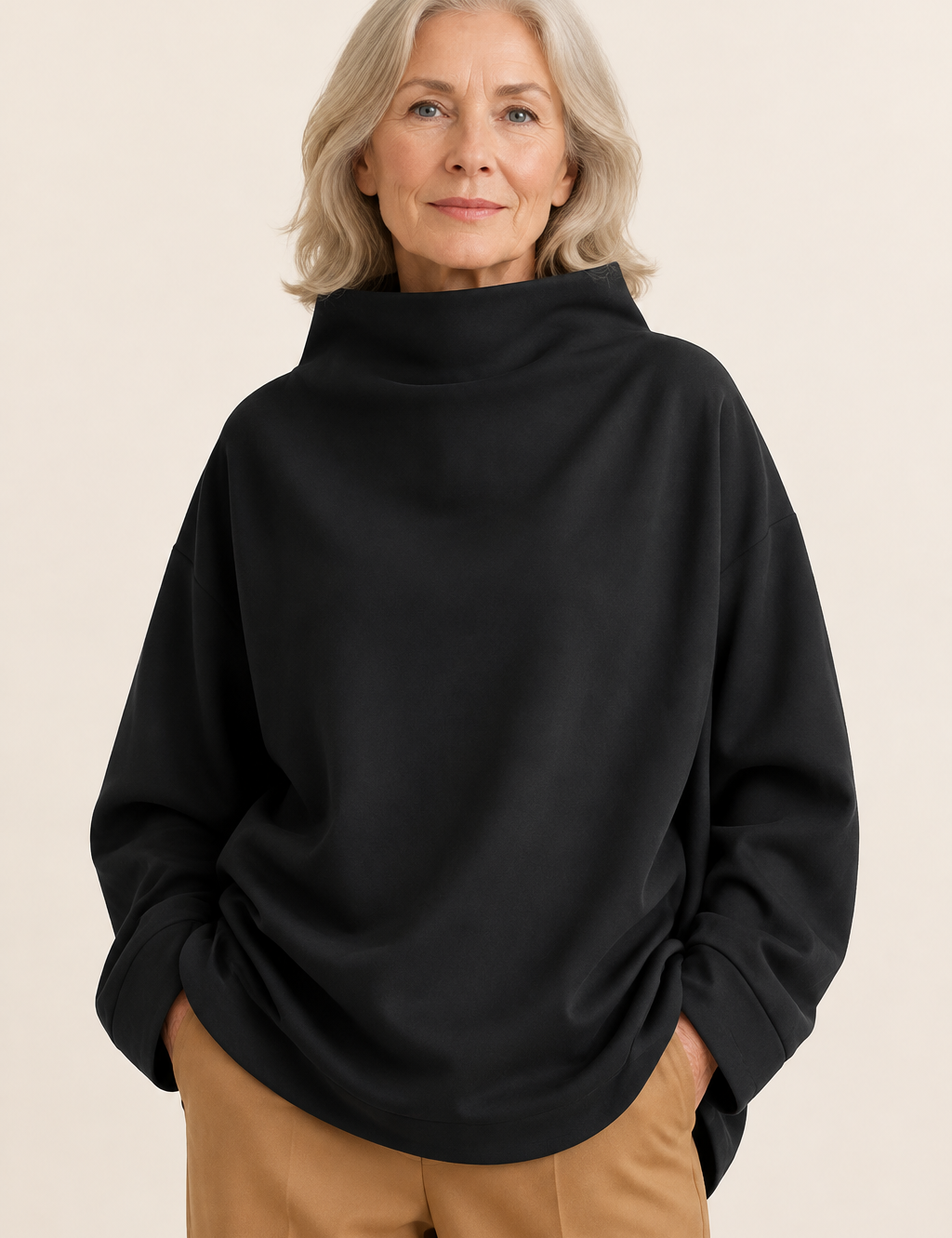 Otilia schwarzer Oversize-Rollkragenpullover an reifer Frau auf warmem beigem Hintergrund
