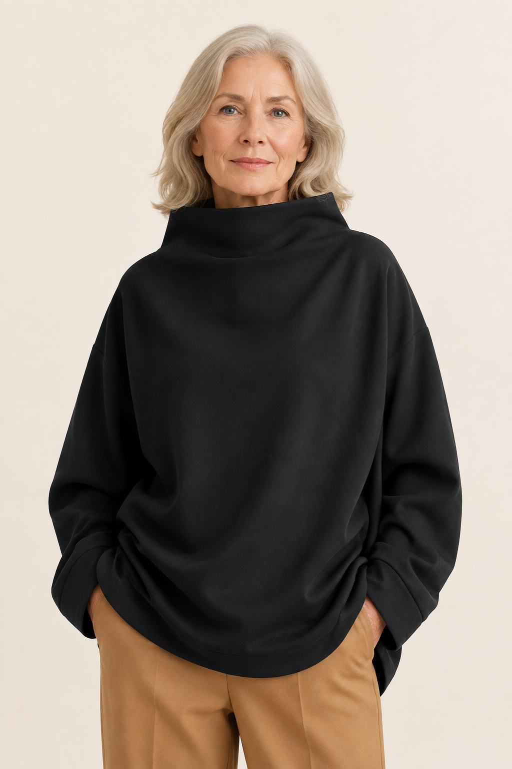 Otilia schwarzer Oversize-Rollkragenpullover an reifer Frau auf warmem beigem Hintergrund