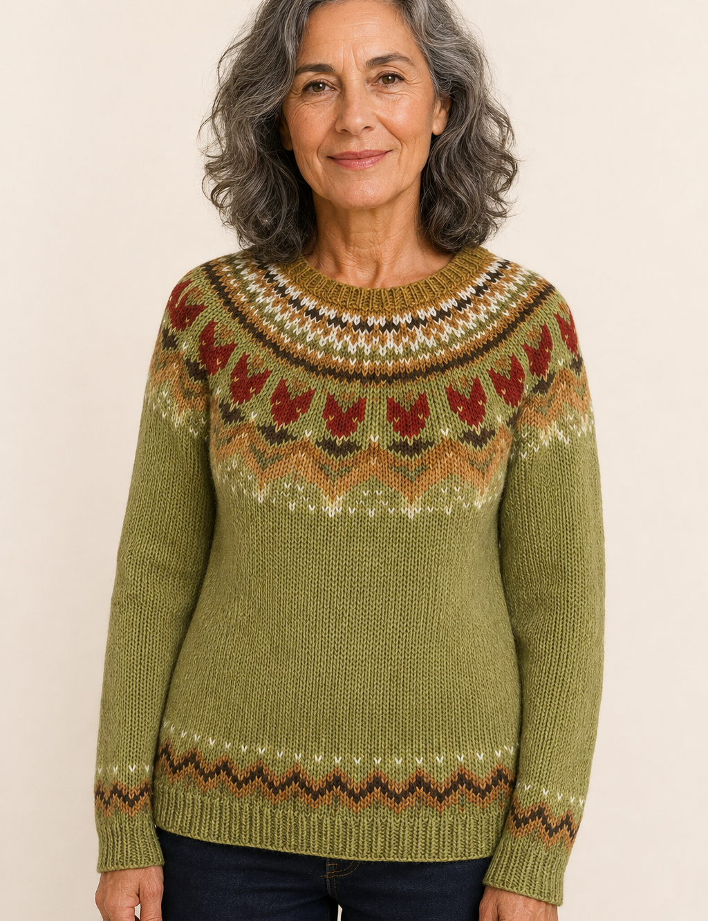 Petra olivgrüner Norwegerpullover an reifer Frau auf warmem beigem Hintergrund