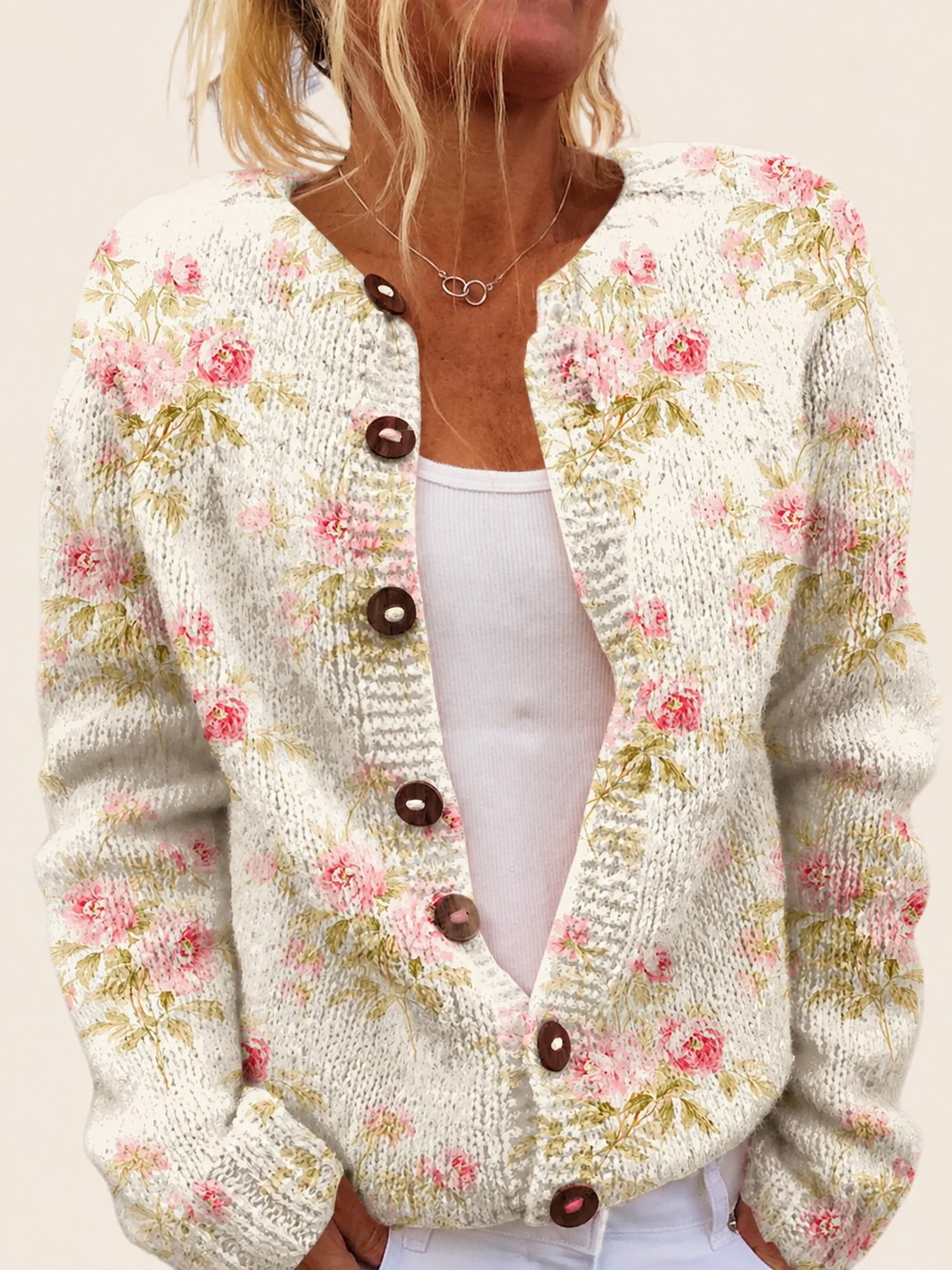 Cardigan mit rosa Blüten und Blättern – warmbeiger Studiohintergrund