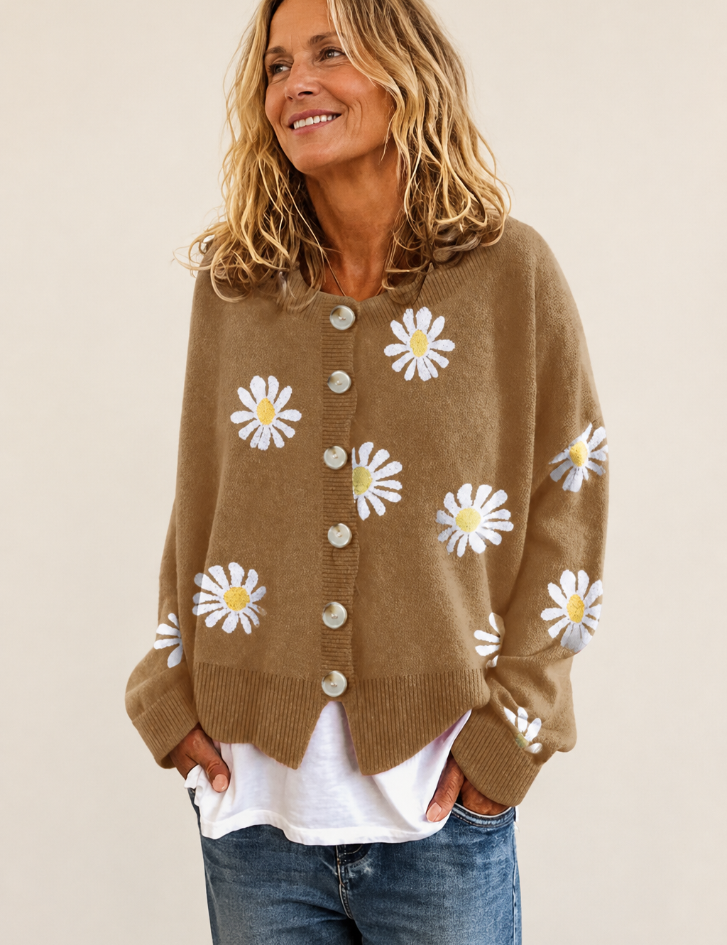 Klassische Strickjacke mit Gänseblümchen auf warmem beigem Hintergrund