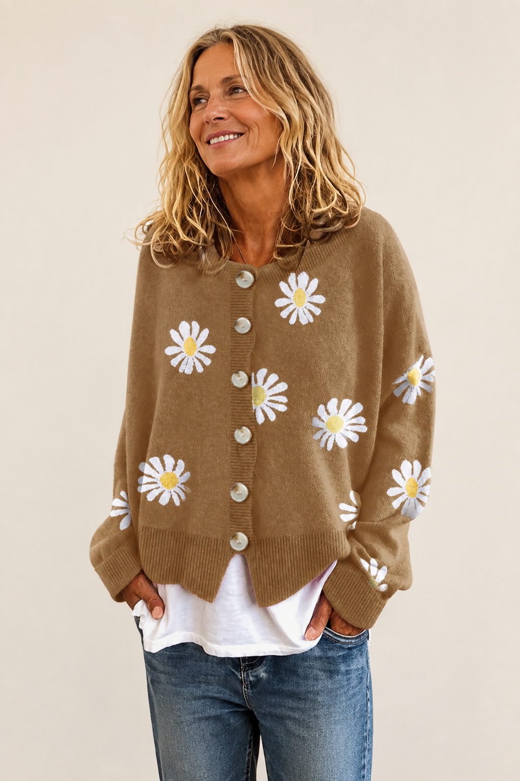 Klassische Strickjacke mit Gänseblümchen auf warmem beigem Hintergrund