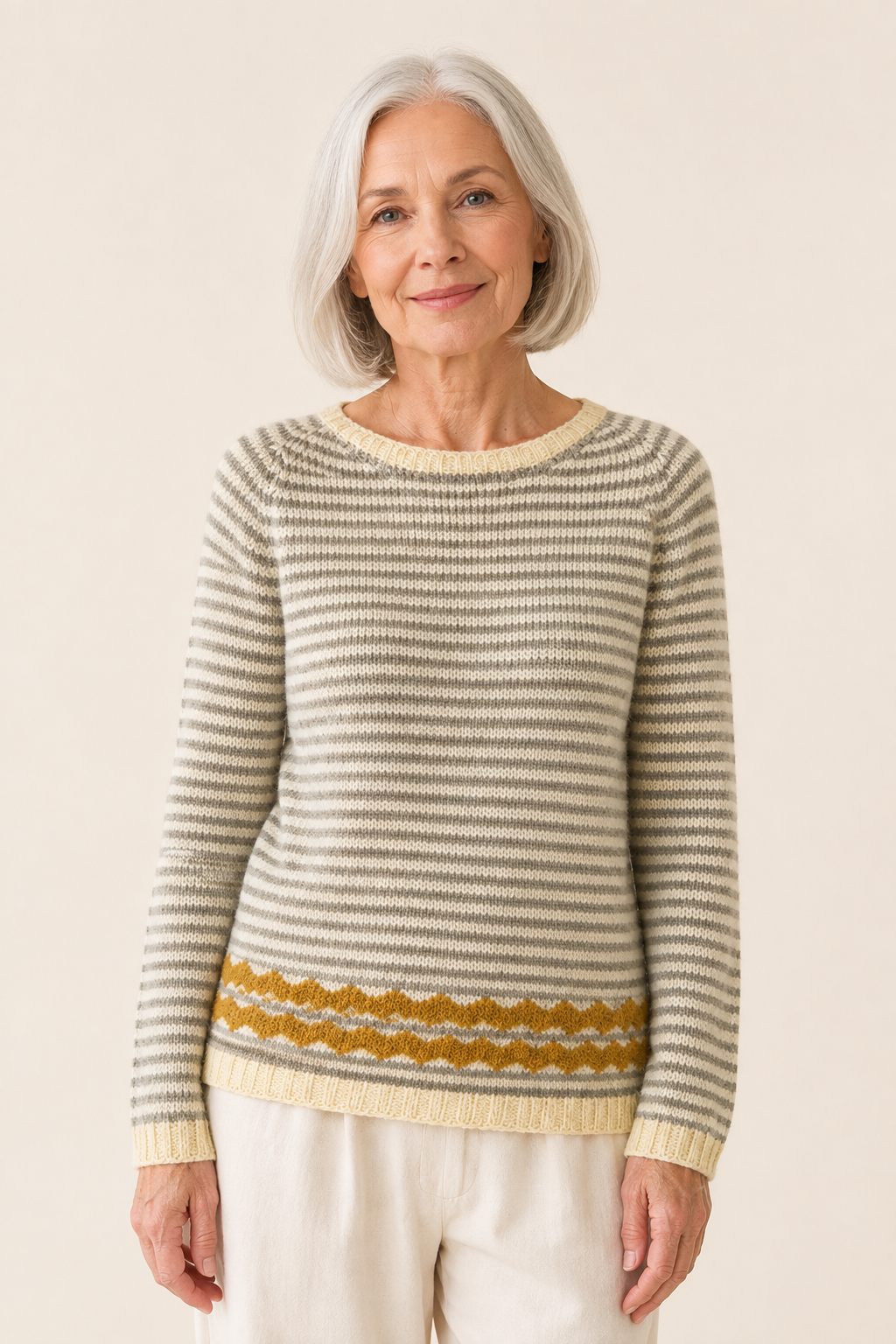 Simona creme-grau gestreifter Pullover an reifer Frau auf warmem beigem Hintergrund