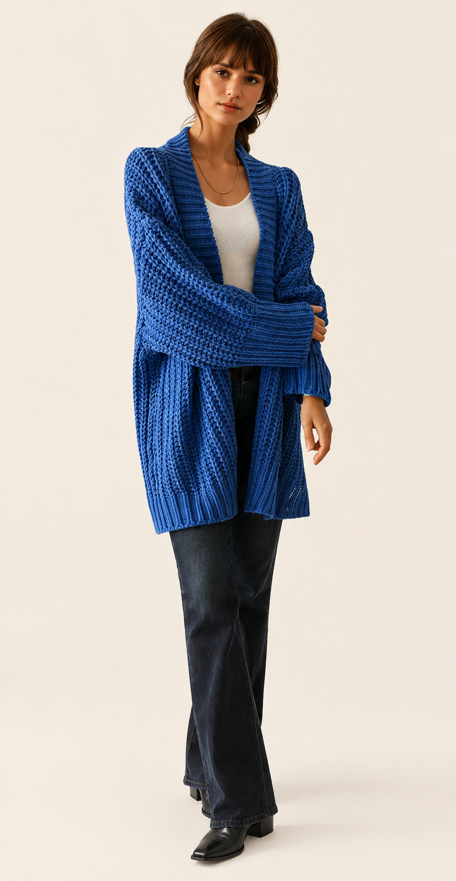 Blaue Oversized Strickjacke auf warmem beigem Hintergrund